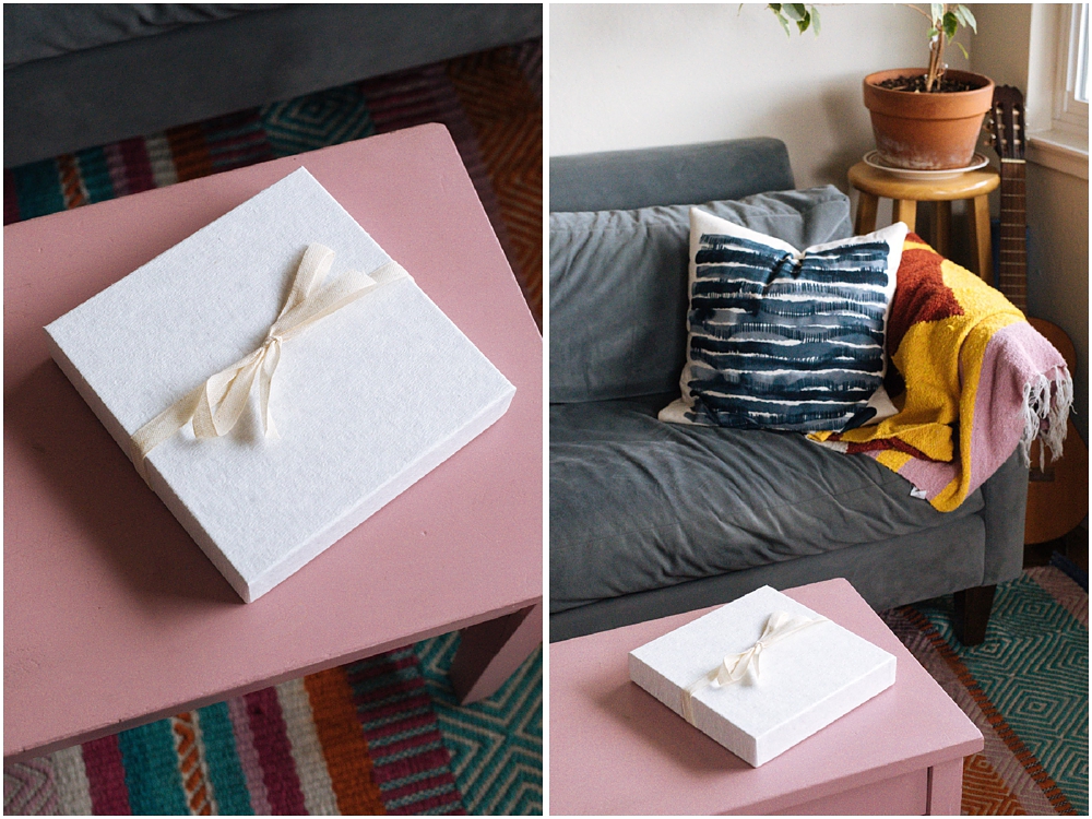 Wedding photography album sits on pink table in box in living room