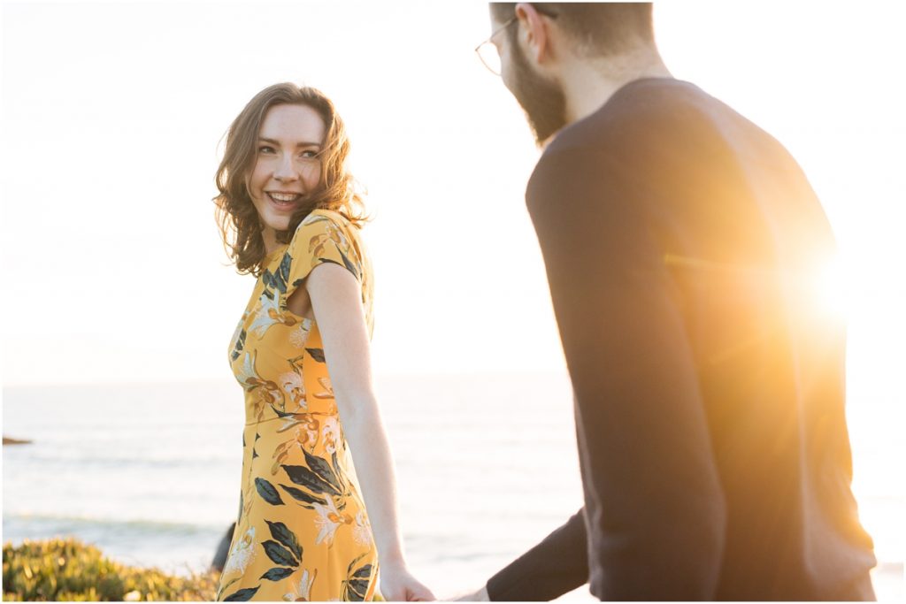 Woman smiles and laughs with partner in the sunshine during their Half Moon Bay engagement photos