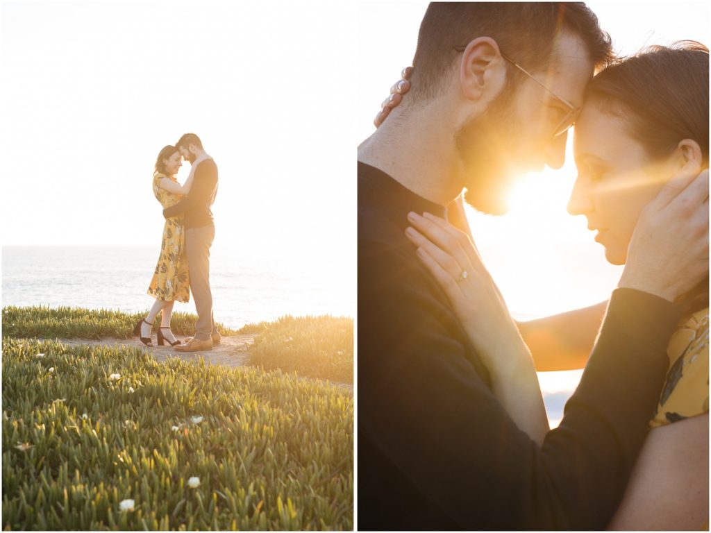 Man and woman embrace during their Half Moon Bay engagement photos on a cliff over the ocean in the sunshine