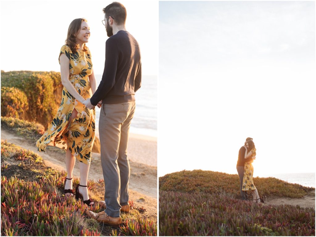 Man and woman embrace while laughing during their Half Moon Bay engagement photos on a cliff over the ocean in the sunshine