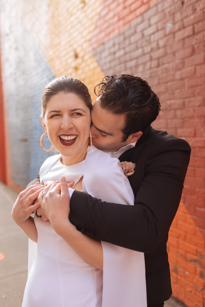 Groom kisses bride on the neck during their Brooklyn elopement