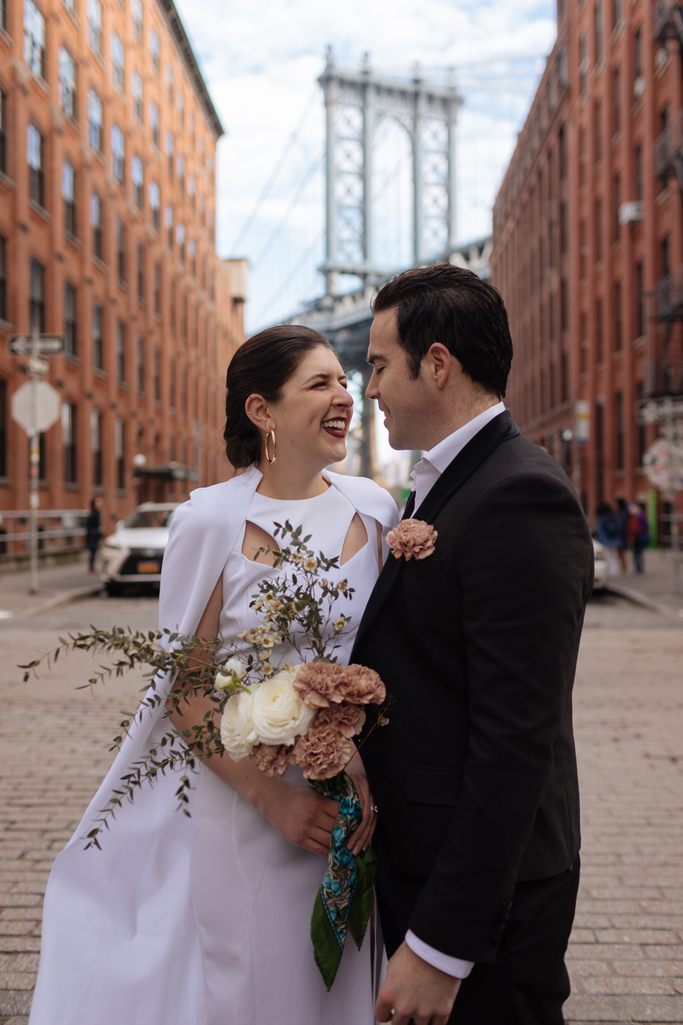 Bride and groom stand in front of the Manhattan Bridge during their morning Brooklyn elopement