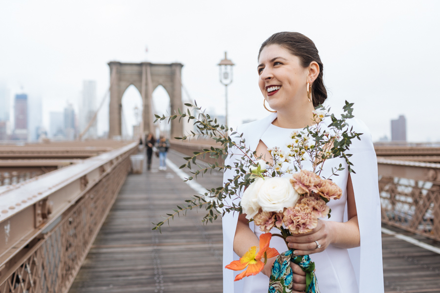 Bride holds her bouquet and laughs during her Brooklyn elopement