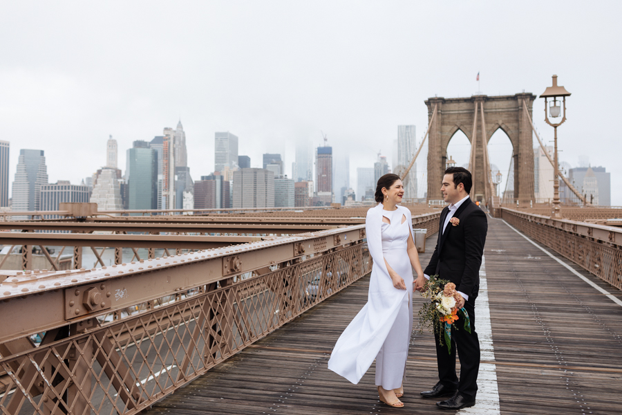 Bride shows groom her wedding dress cape during their Brooklyn elopement
