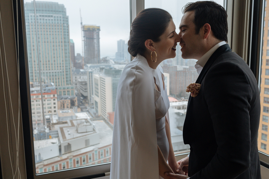 Bride and groom kiss in their apartment before their Brooklyn elopement