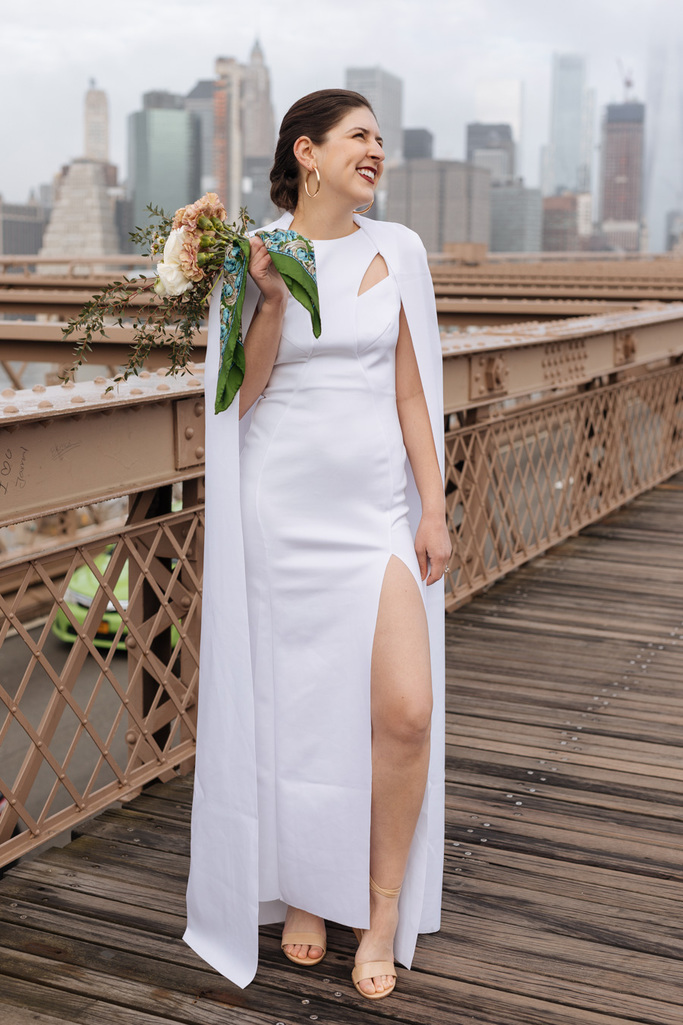 The bride shows off the slit in her fantastic and fashionable dress during her Brooklyn elopement