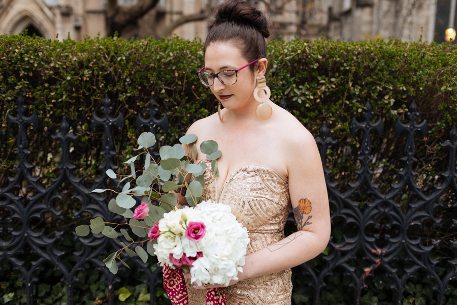 Bride in a gold chandelier dress holds her bouquet during her East Village elopement