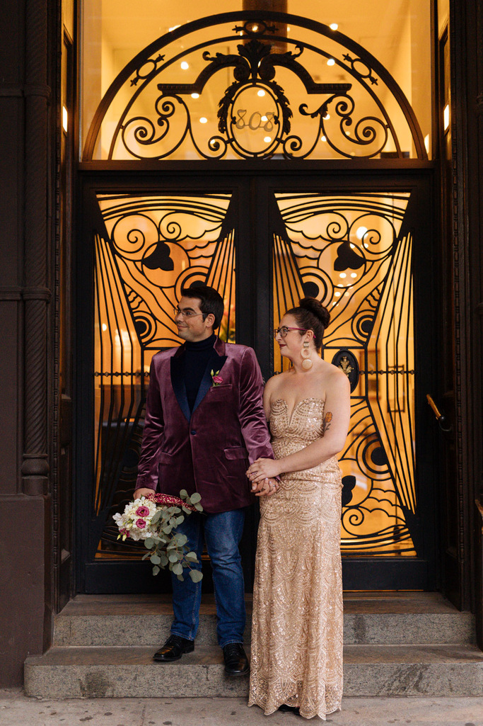 bride and groom stand in a doorway at dusk in NYC during their West Village elopement