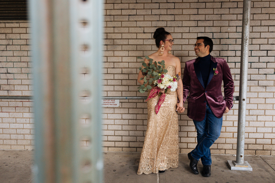 Hip bride and groom stand in an urban area of New York City after their East Village elopement