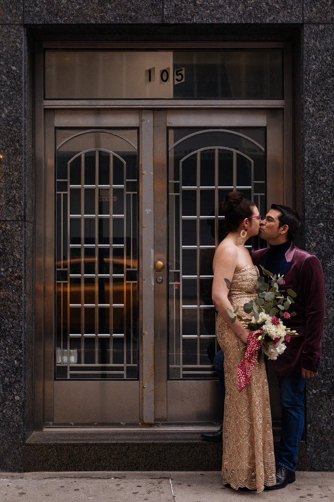 Bride and groom kiss in a doorway in NYC during their East Village elopement