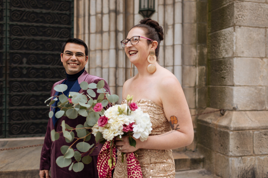Bride and groom walk together past the Grace Church during their East Village elopement in NYC