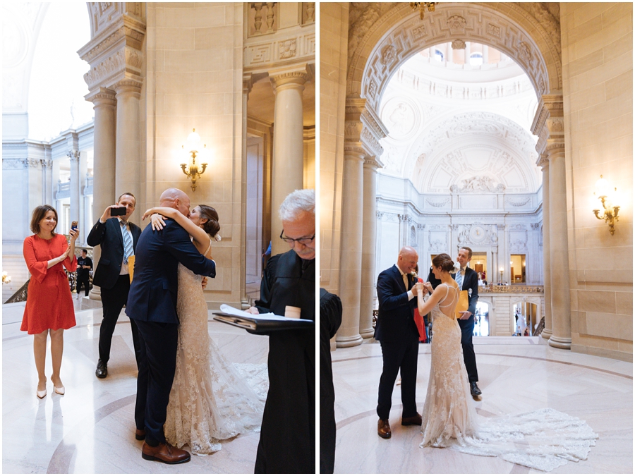 Couple shares their first kiss in the rotunda during their wedding ceremony at their San Francisco City Hall wedding in California