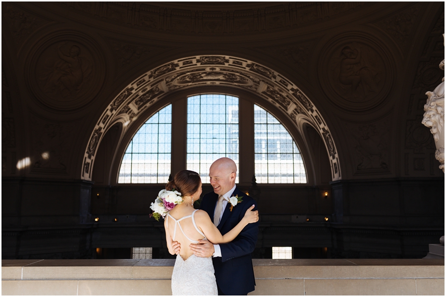 Couple hugs and smiles during their San Francisco City Hall wedding in California