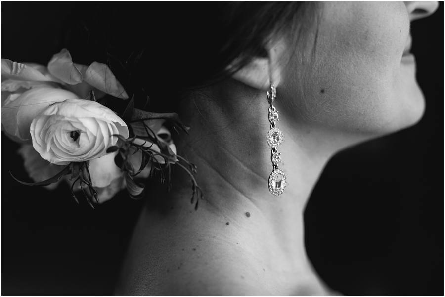 Detail shot of bride's crystal earring and flowers in her hair during her wedding 