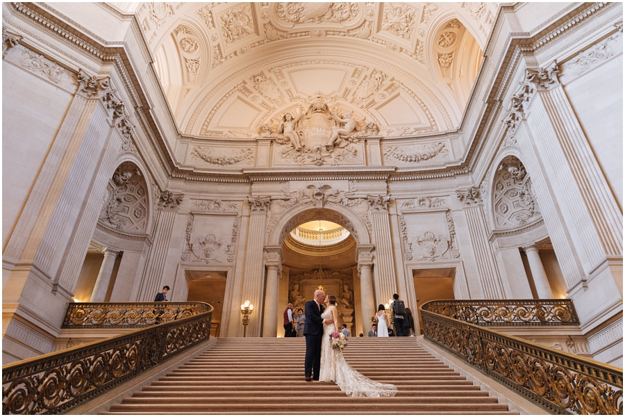 Bride and groom stand on the Grand Staircase at San Francisco City Hall before their San Francisco picnic wedding reception