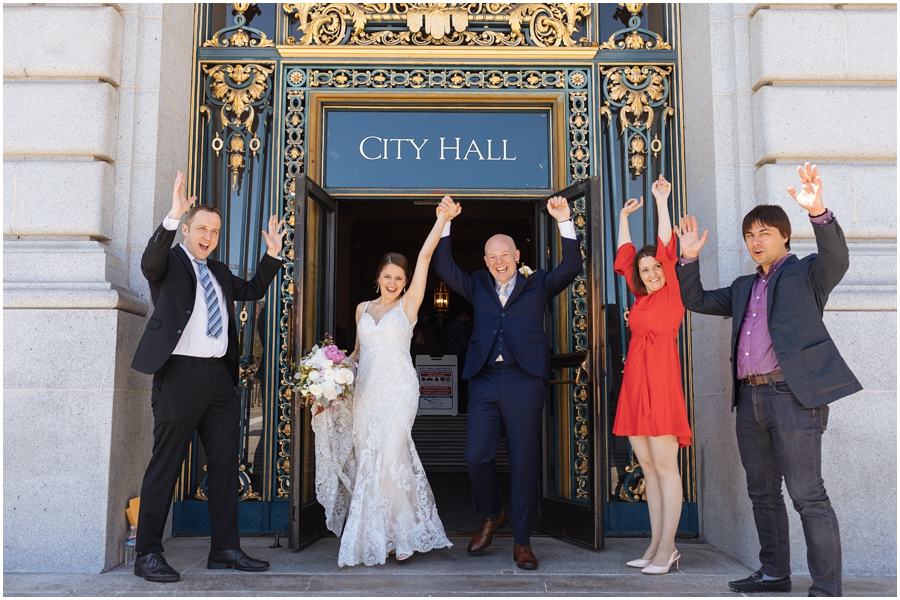Bride, groom, and their friends celebrate after they get married at San Francisco City Hall.
