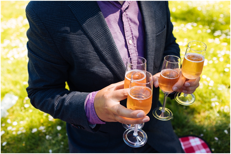 Friend holds champagne flutes during the San Francisco picnic wedding reception