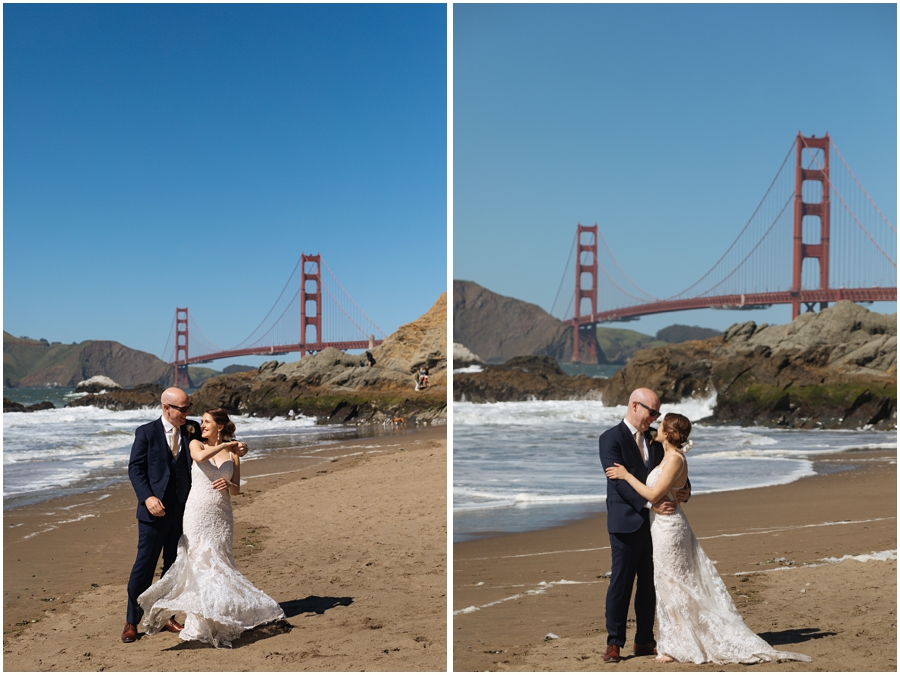 Bride and groom stand on the sand at Baker Beach in front of the Golden Gate Bridge during their San Francisco picnic wedding on the beach