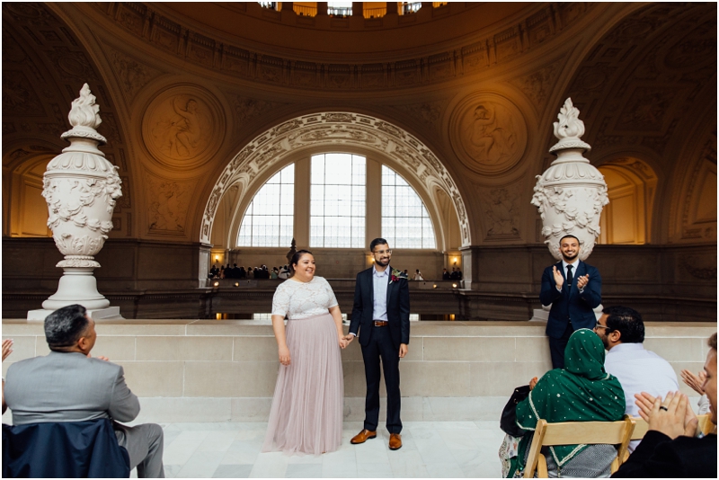 A marriage ceremony in the fourth floor north gallery in San Francisco City Hall during a one hour ceremony with folding chairs