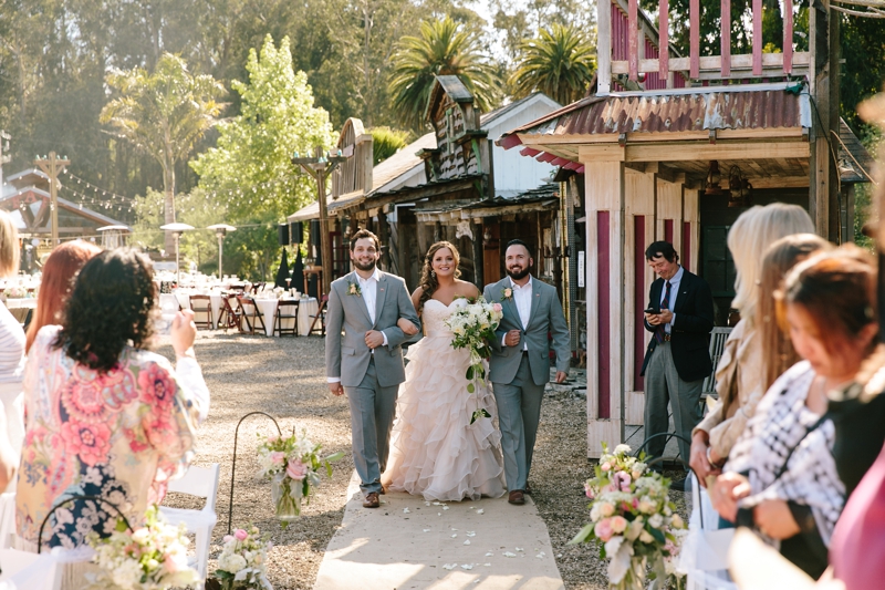 Bride walks down the aisle with her brothers during a wedding at the Long Brand Saloon and Farms, Half Moon Bay wedding venue