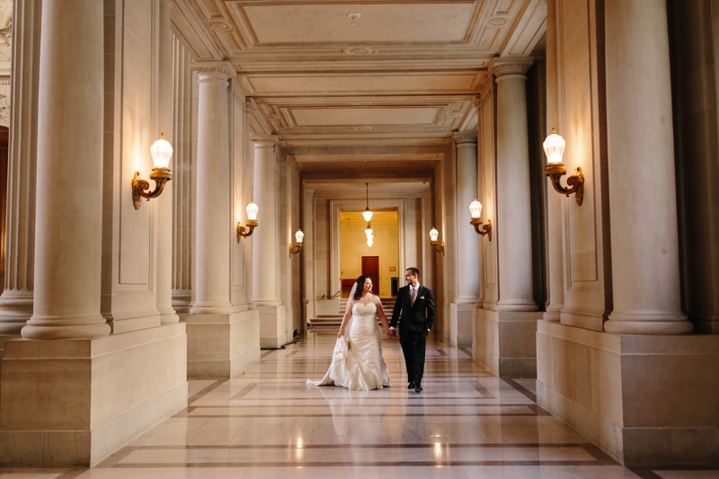 Bride and groom walks through San Francisco City Hall