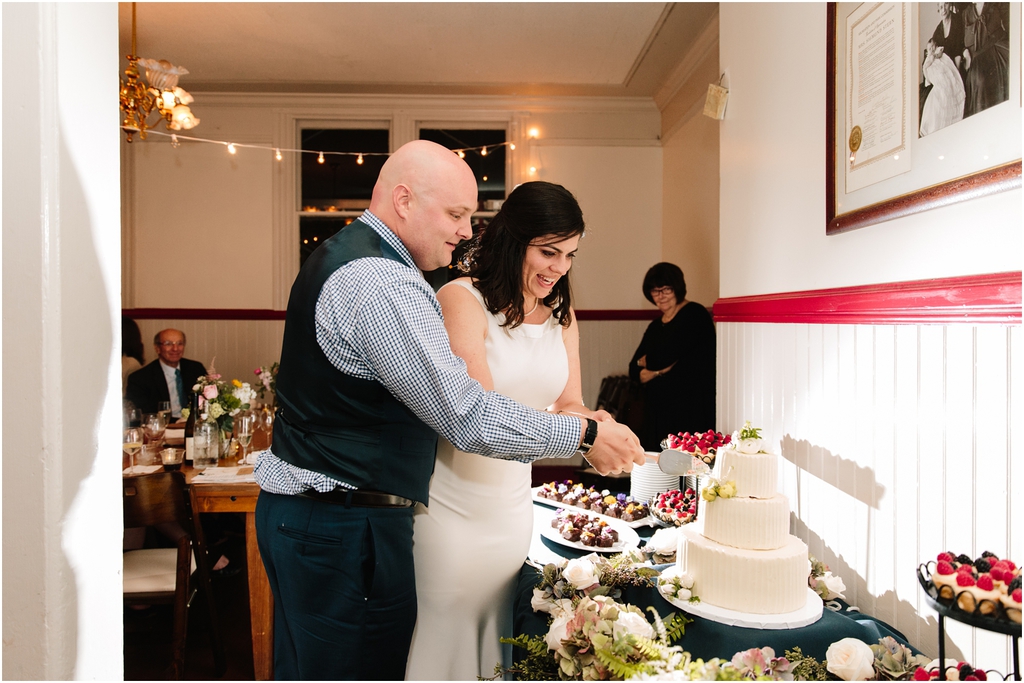 Bride and groom cut the cake during their stern grove wedding