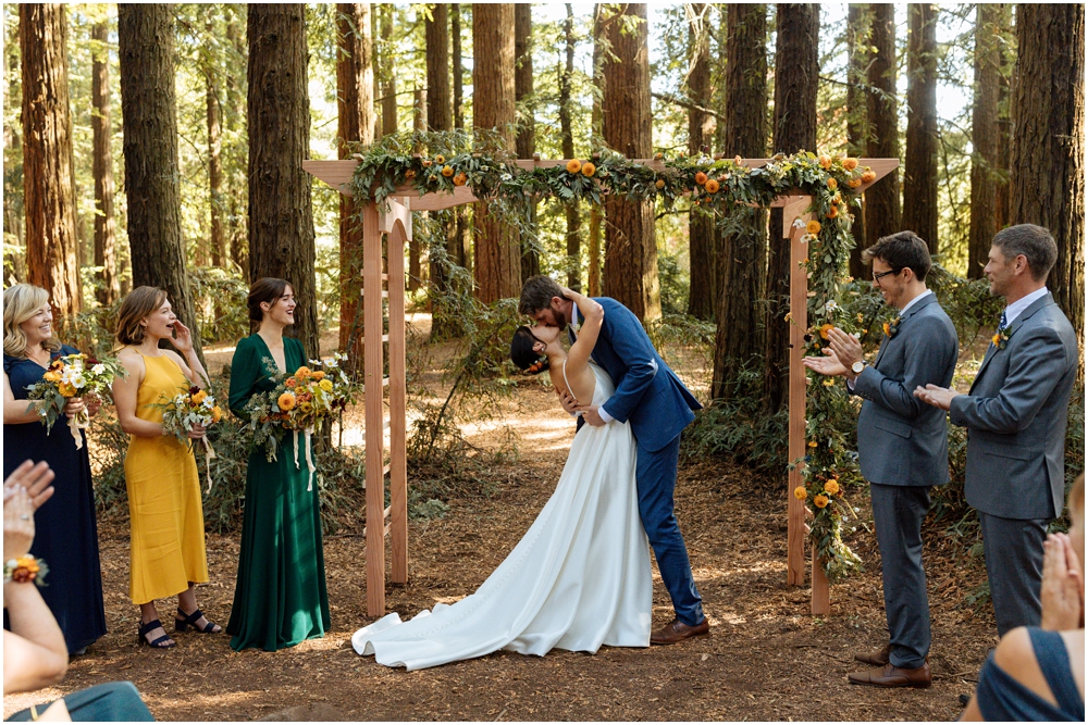 A first kiss at the ceremony site in Redwood Regional park, among the redwoods